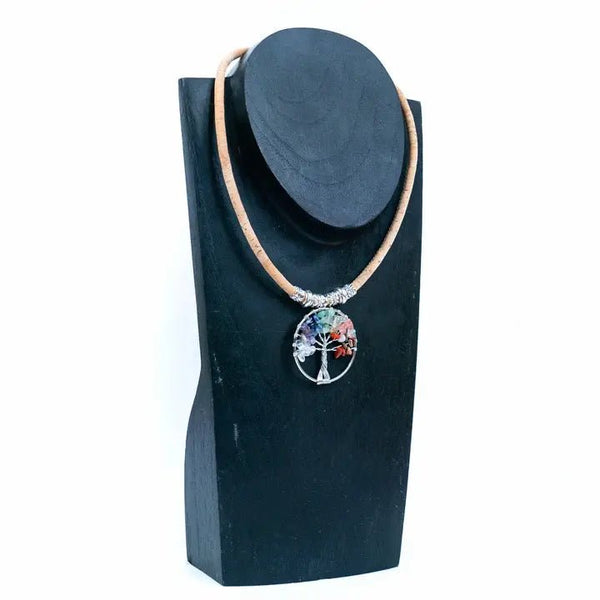 Necklace with a colorful tree pendant on a black stand against a white background