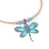 Close up of cork necklace with a dragonfly pendant featuring turquoise stones on a white background
