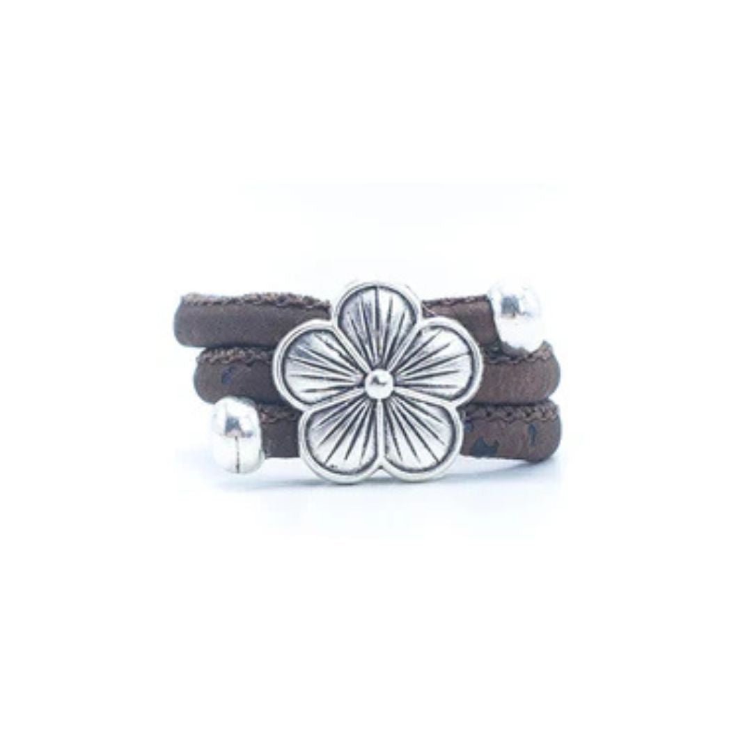 Brown cork ring with a silver vintage floral charm on a white background
