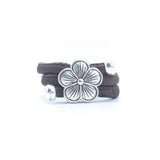 Brown cork ring with a silver vintage floral charm on a white background