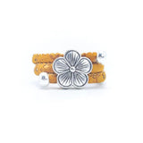 Gold cork ring with a silver vintage floral charm on a white background