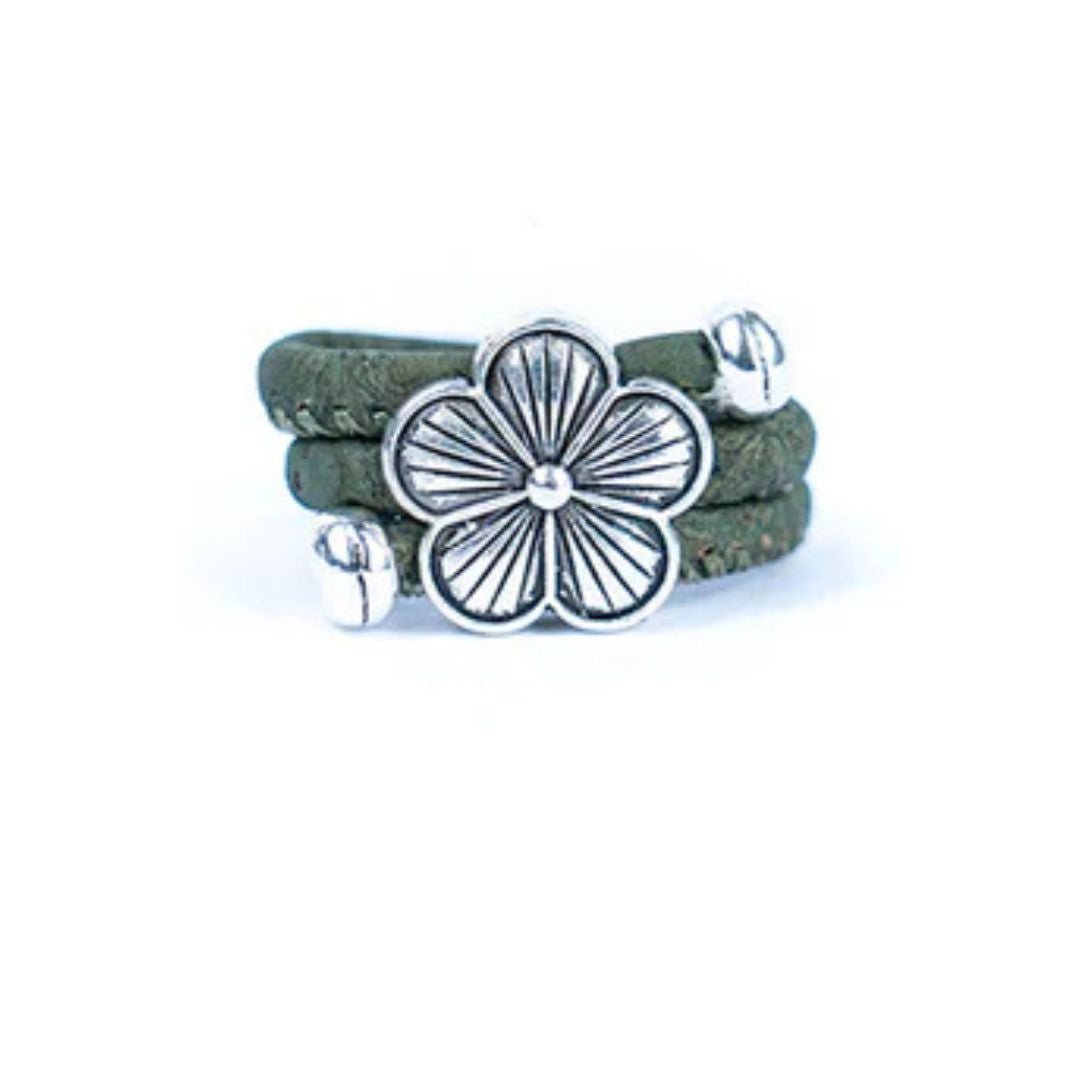 Grey cork ring with a silver vintage floral charm on a white background