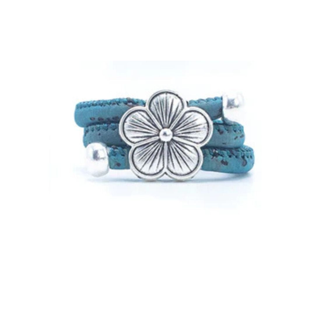 Teal cork ring with a silver vintage floral charm on a white background