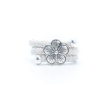 White cork ring with a silver vintage floral charm on a white background