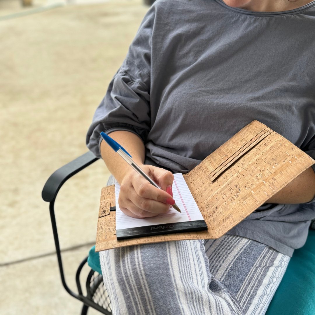 Woman writing in Cork Leather covers notebook by Texas Cork Company.