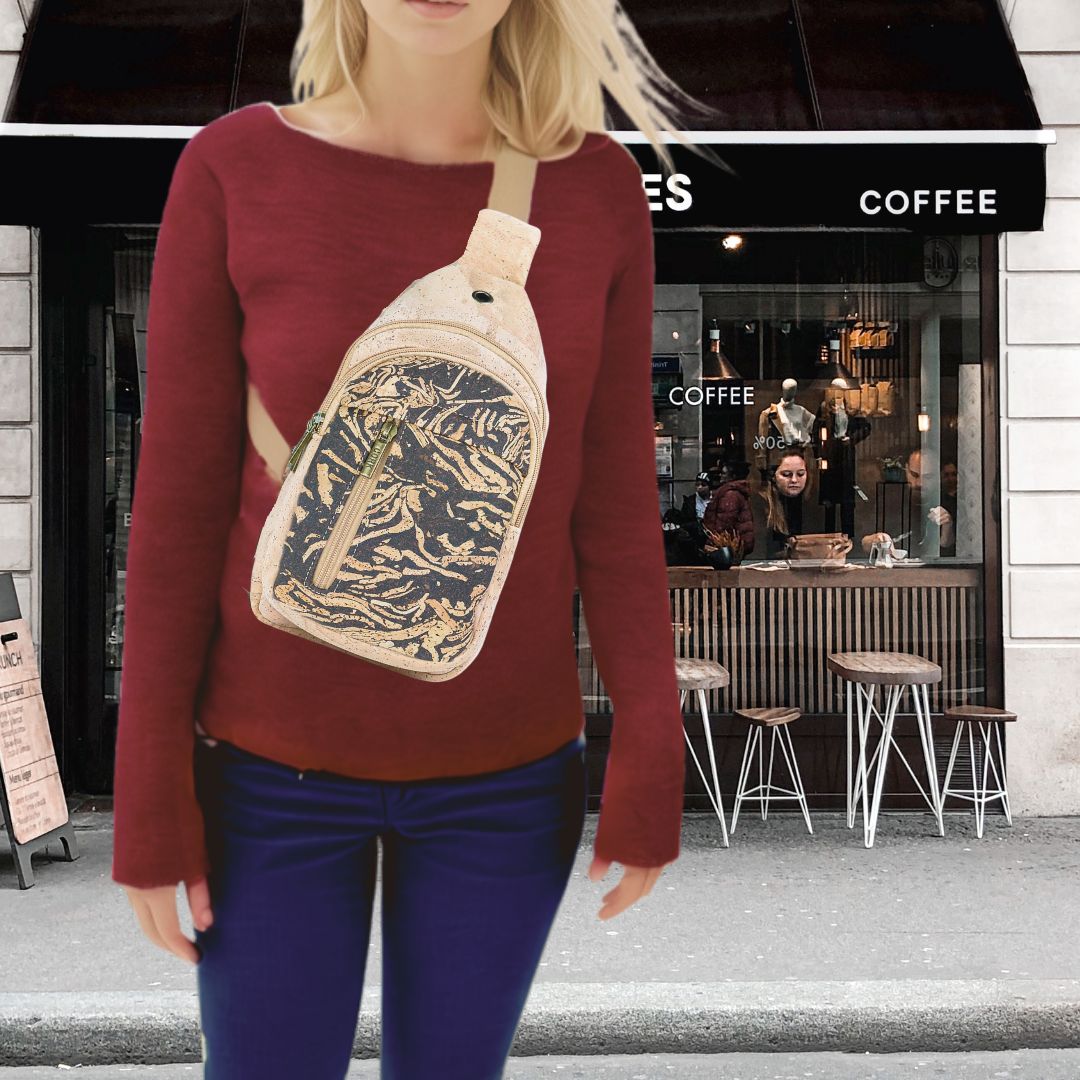 Woman wearing the Dark Roast version of the Coffee and Cork Chest Sling Bag in front of a coffee shop. Texas Cork Company.