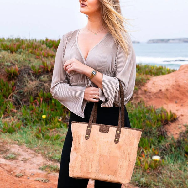 Woman holding Kona Cork Tote Bag by the ocean