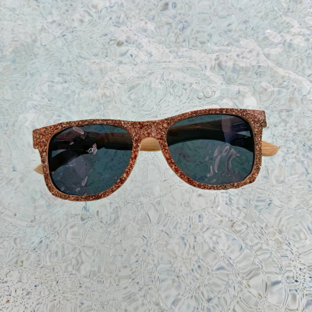 Eco-friendly cork and bamboo sunglasses with polarized lenses floating in water