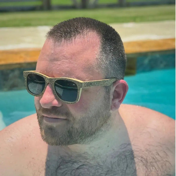 Man wearing cork sunglasses by a pool