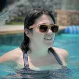 Woman wearing cork sunglasses in a pool