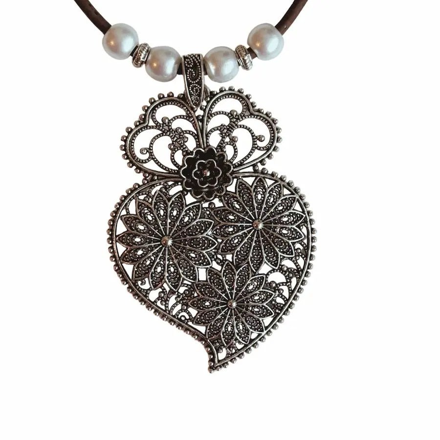 Close-up of antique floral pendant and brown cork cord