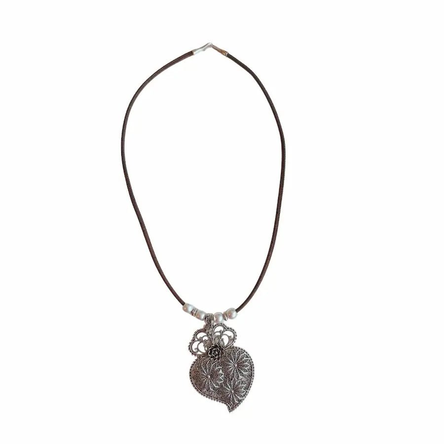 Handcrafted cork necklace with antique floral pendant on white background