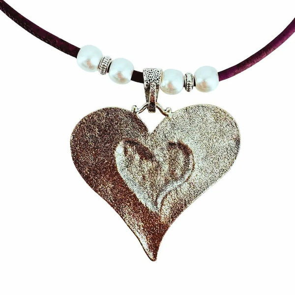 Heart-shaped silver pendant back on a purple cord with pearl-like beads