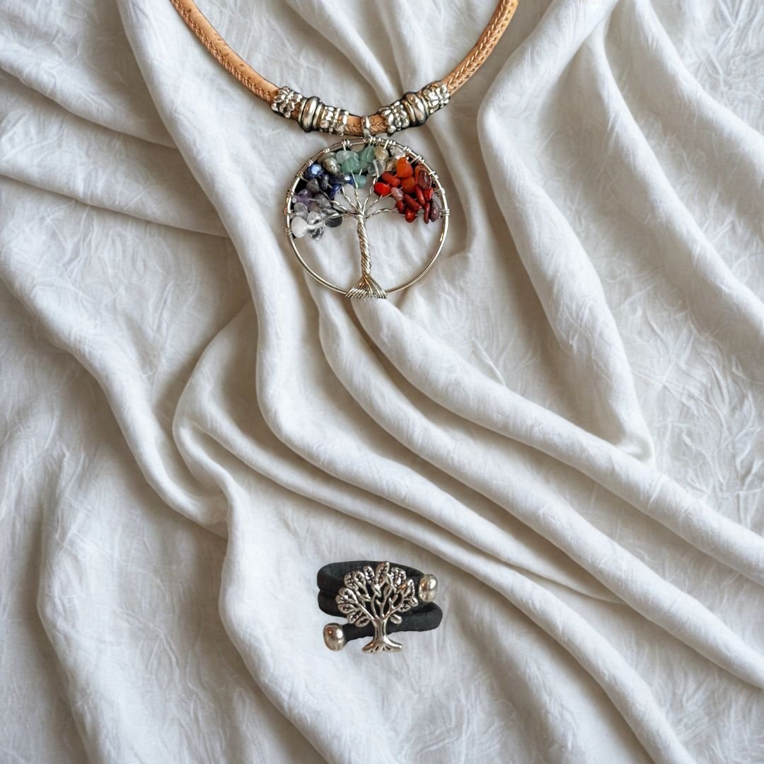 Necklace with a tree of life pendant and a cork ring with a tree pendant on a white fabric background