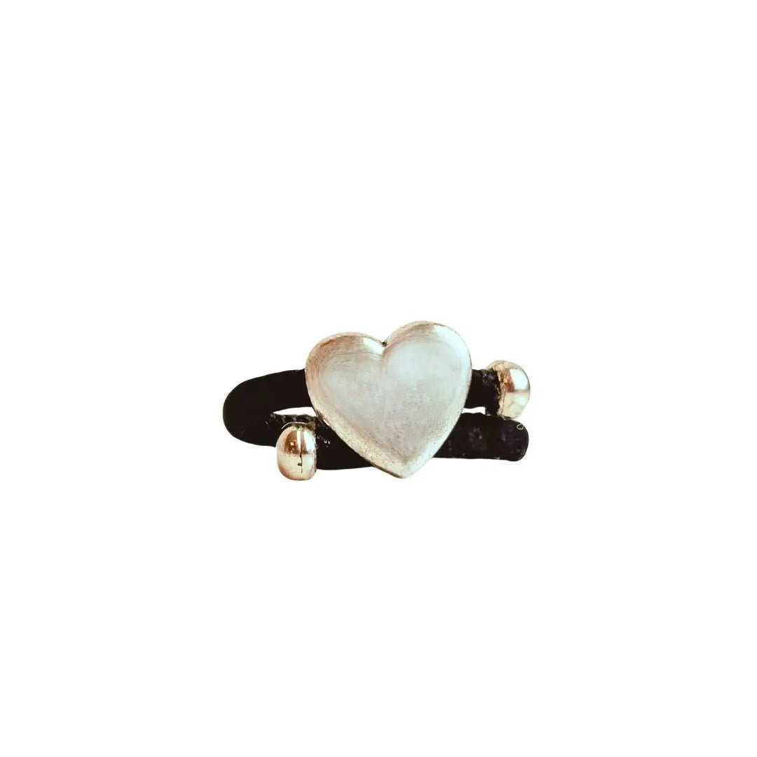 Heart-shaped silver with black cork cord ring on a white background