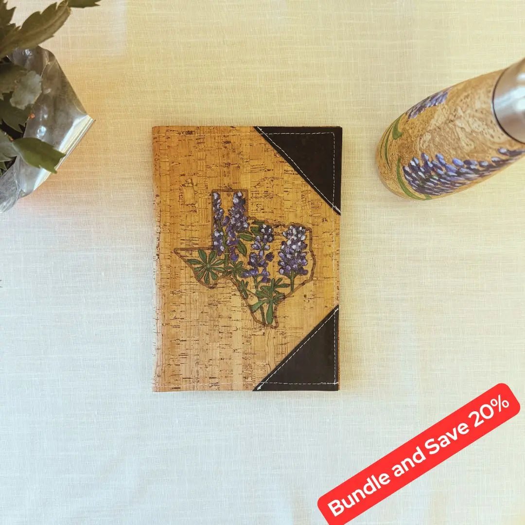 Hand painted water bottle and outside notebook cover on a table with a coffee mug