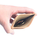 Minimalist cork card wallet with RFID protection and ID window showing coins in middle slot from Texas Cork Company