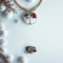 Necklace with a tree of life pendant on a snowy background with black cork ring
