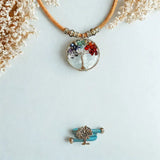 Necklace with a tree of life pendant on a snowy background with blue cork ring