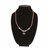 Necklace of pink cork cord with a bee charm on a black velvet stand against a white background