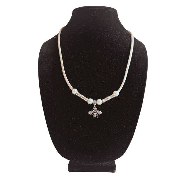 Whimsical bee charm cork necklace on jewelry bust made with white cork cord