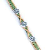 Bracelet with green and natural twisted design and silver daisy charms lying flat on a white background