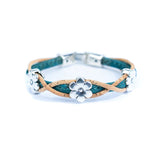 Bracelet with teal and natural cork design and silver daisy charms on a white background
