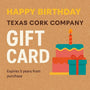 Gift Card for Birthday with cake and wrapped gift on cork background.