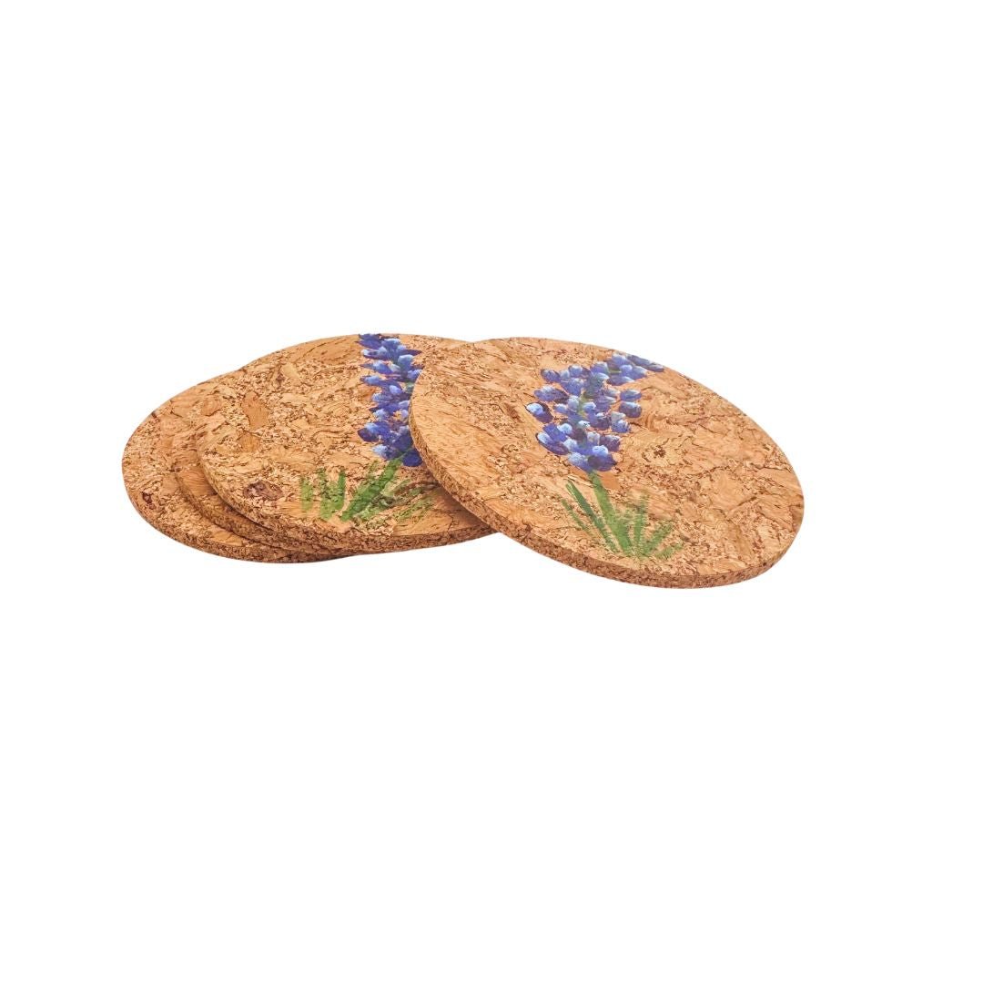 Set of four cork coasters with hand painted bluebonnet design on a white background