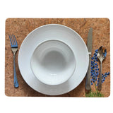 Handpainted cork table mat with white bowl, fork, knife, and spoon on a white background
