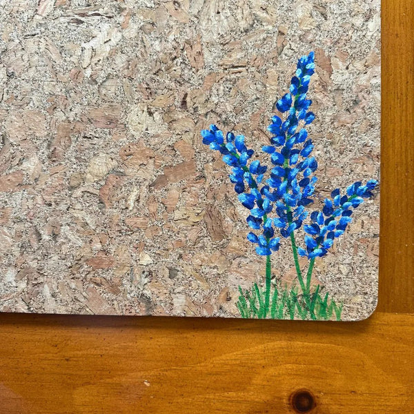 Closeup of handprinted bluebonnets on cork placemat