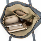 Interior of Laguna Sunshine tote with journal, address book, cell phone, small cosmetics case, sunglasses, keys, and a small wallet.