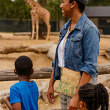 Woman l wearing a Green Summerville Cork Bag Crossbody with her two children observing a giraffe at a zoo