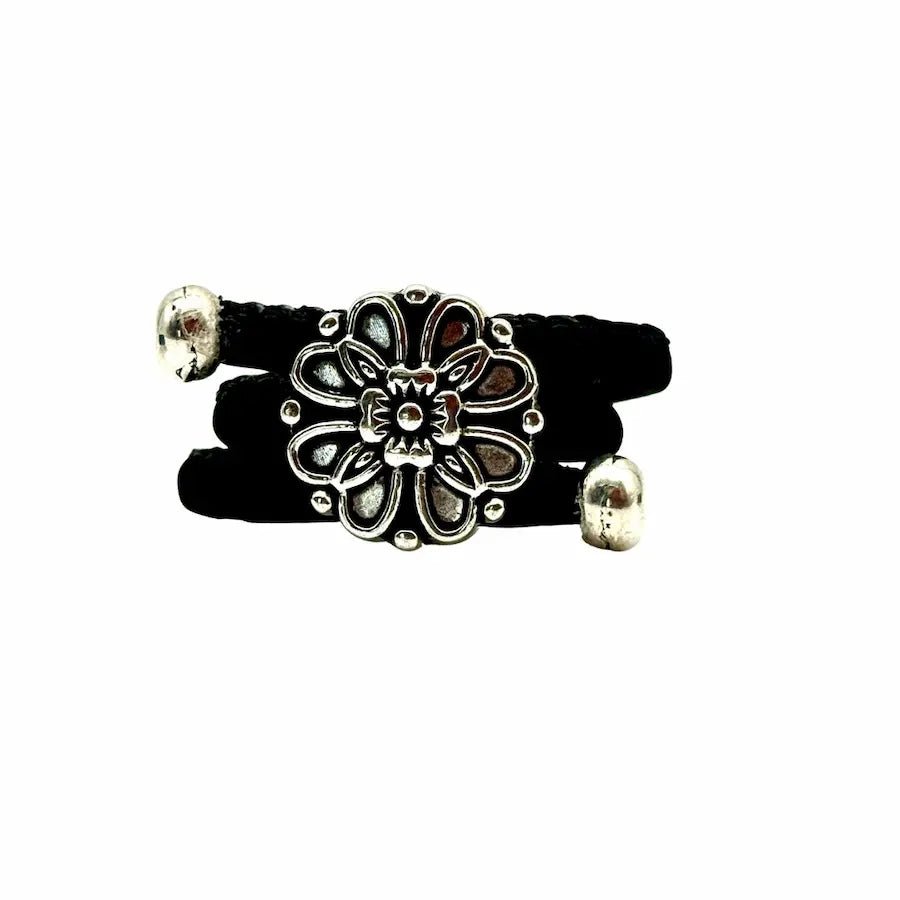 Black ring with a silver vintage floral charm on a white background