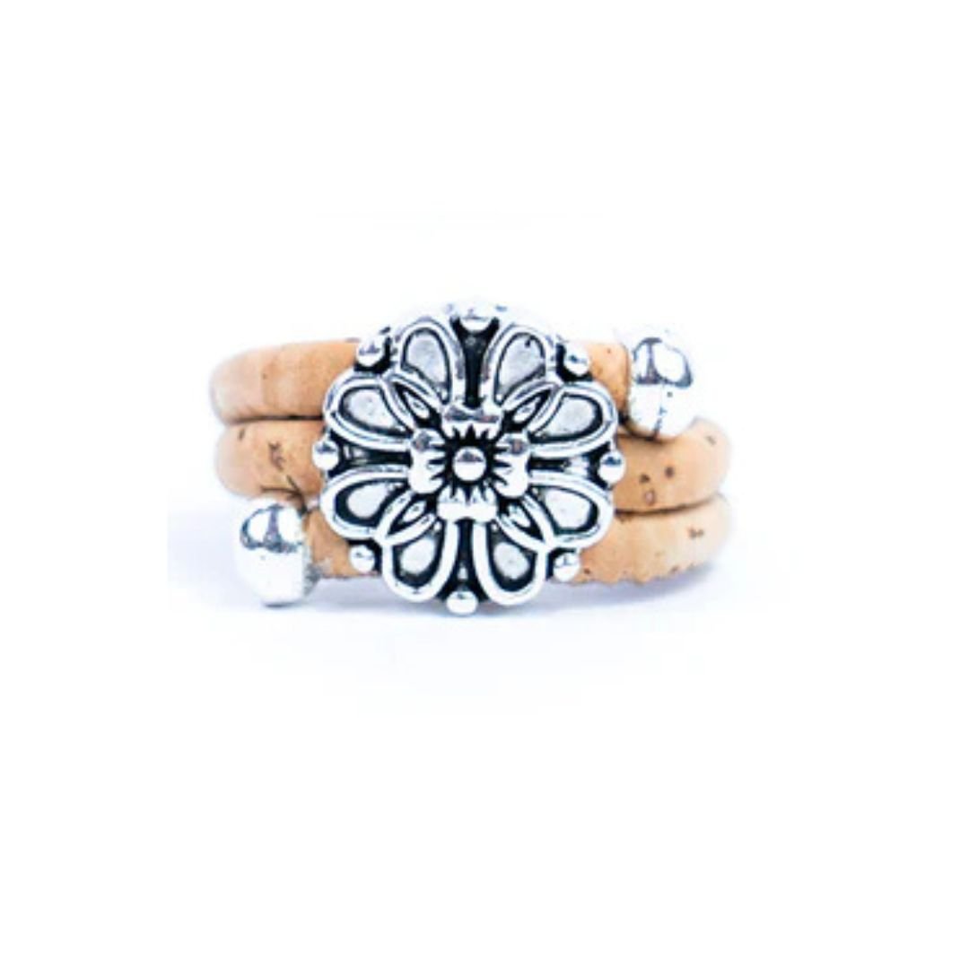 Natural cork ring with a silver vintage floral charm on a white background