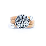Natural cork ring with a silver vintage floral charm on a white background