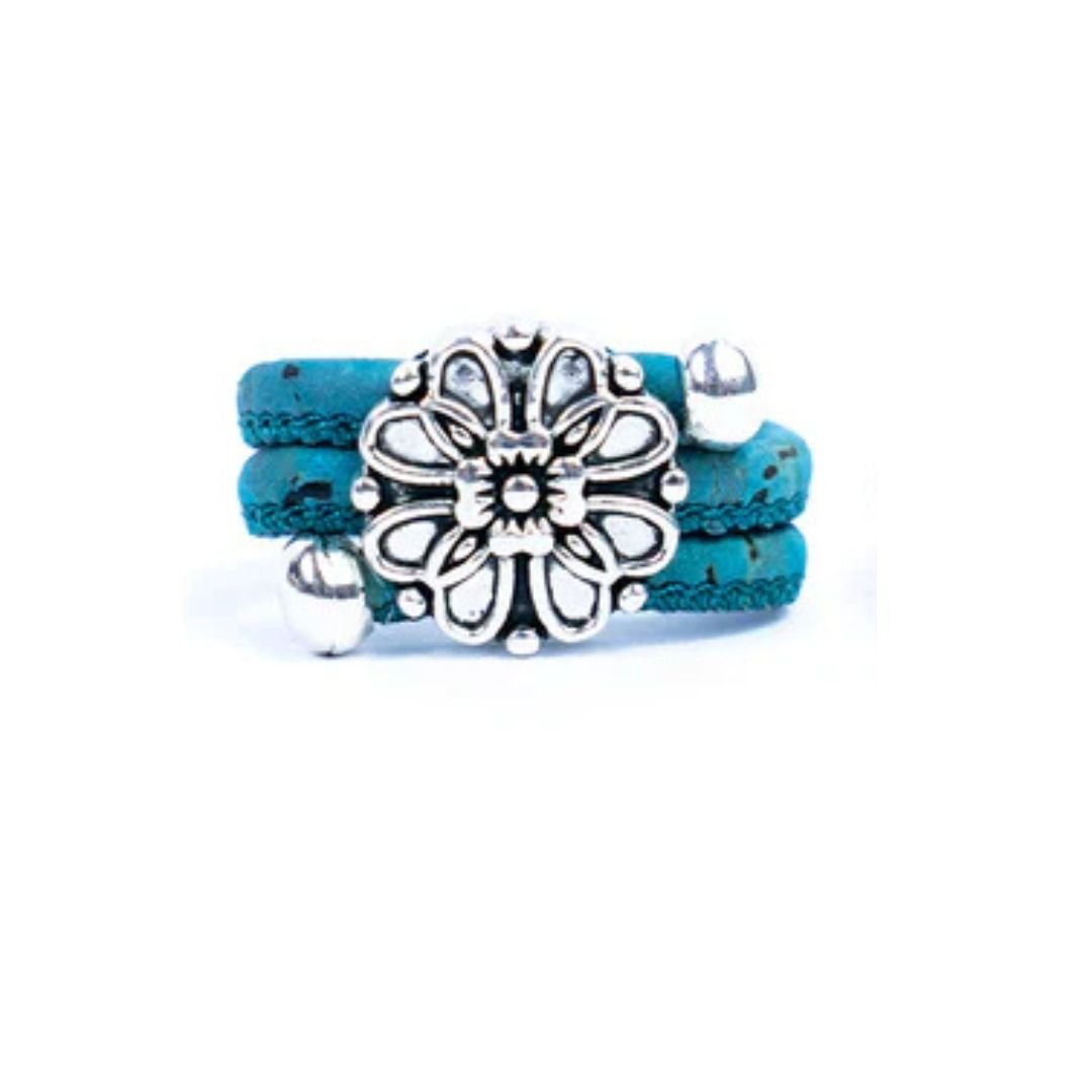 Teal cork ring with a silver vintage floral charm on a white background