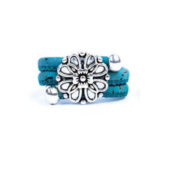 Teal cork ring with a silver vintage floral charm on a white background