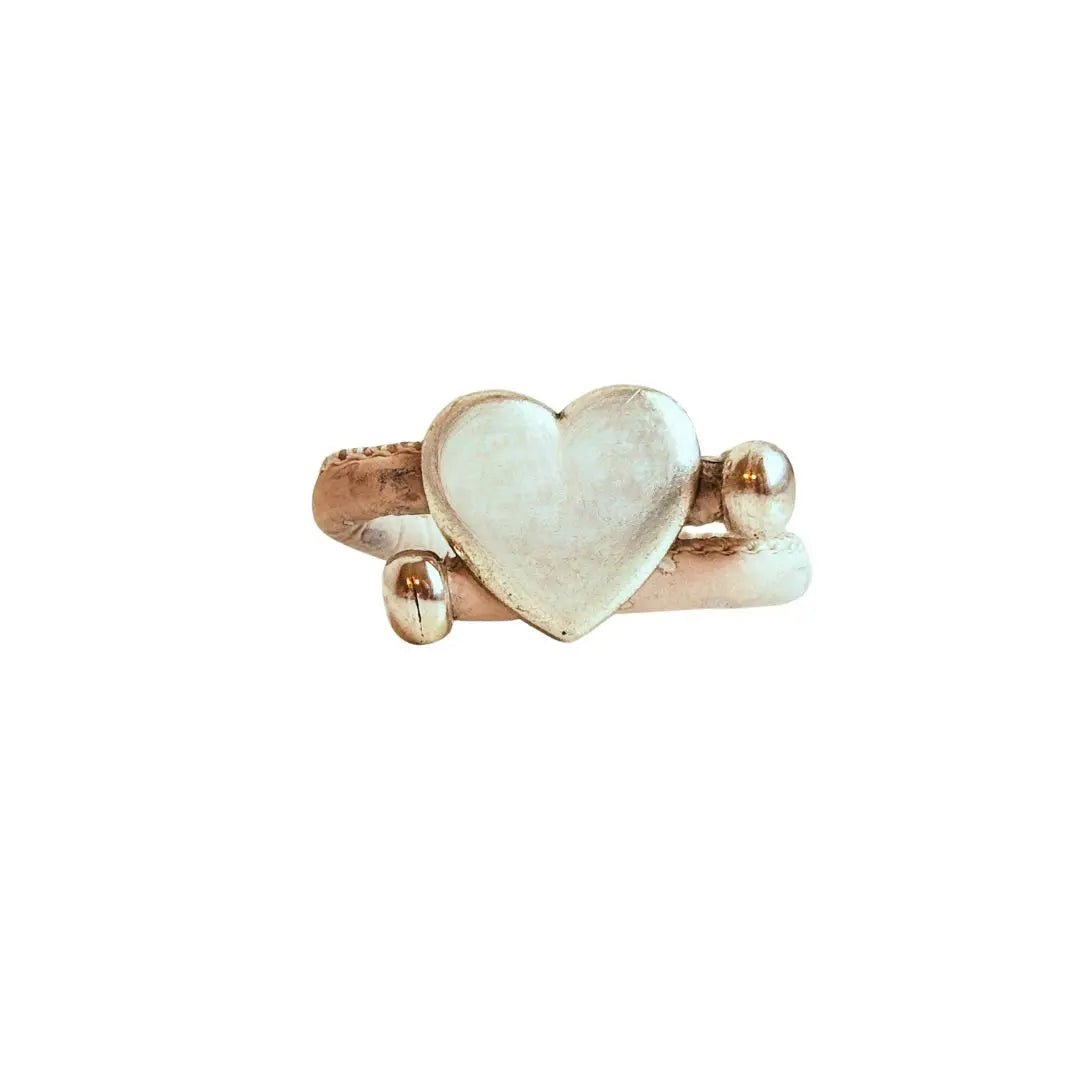 Heart-shaped silver with white cork cord ring on a white background