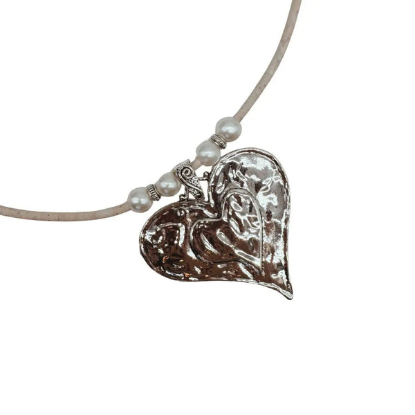 Heart-shaped silver pendant on a white cork cord with pearl-like beads