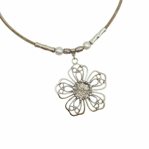 Closeup of back of wire flower pendant with turquoise center on mint colored cork cord