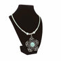 Mint cork cord necklace with wire flower pendant on a black stand against a white background