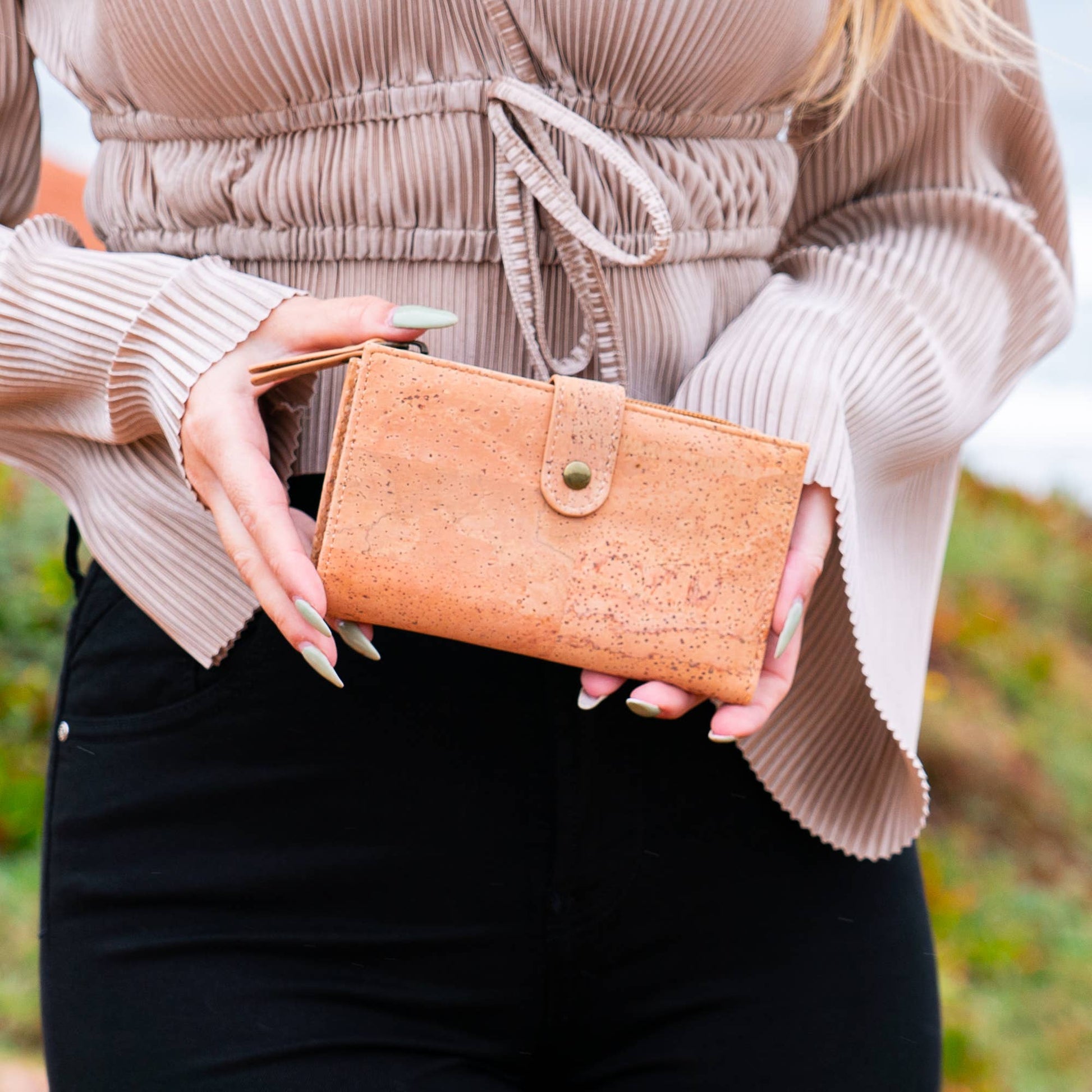 Woman holding natural chic cork wallet with snap closure from Texas Cork Company